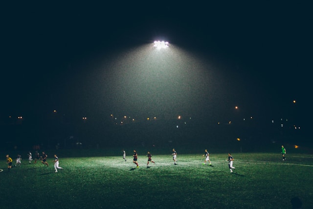 A group of friends playing a casual game of football on grass